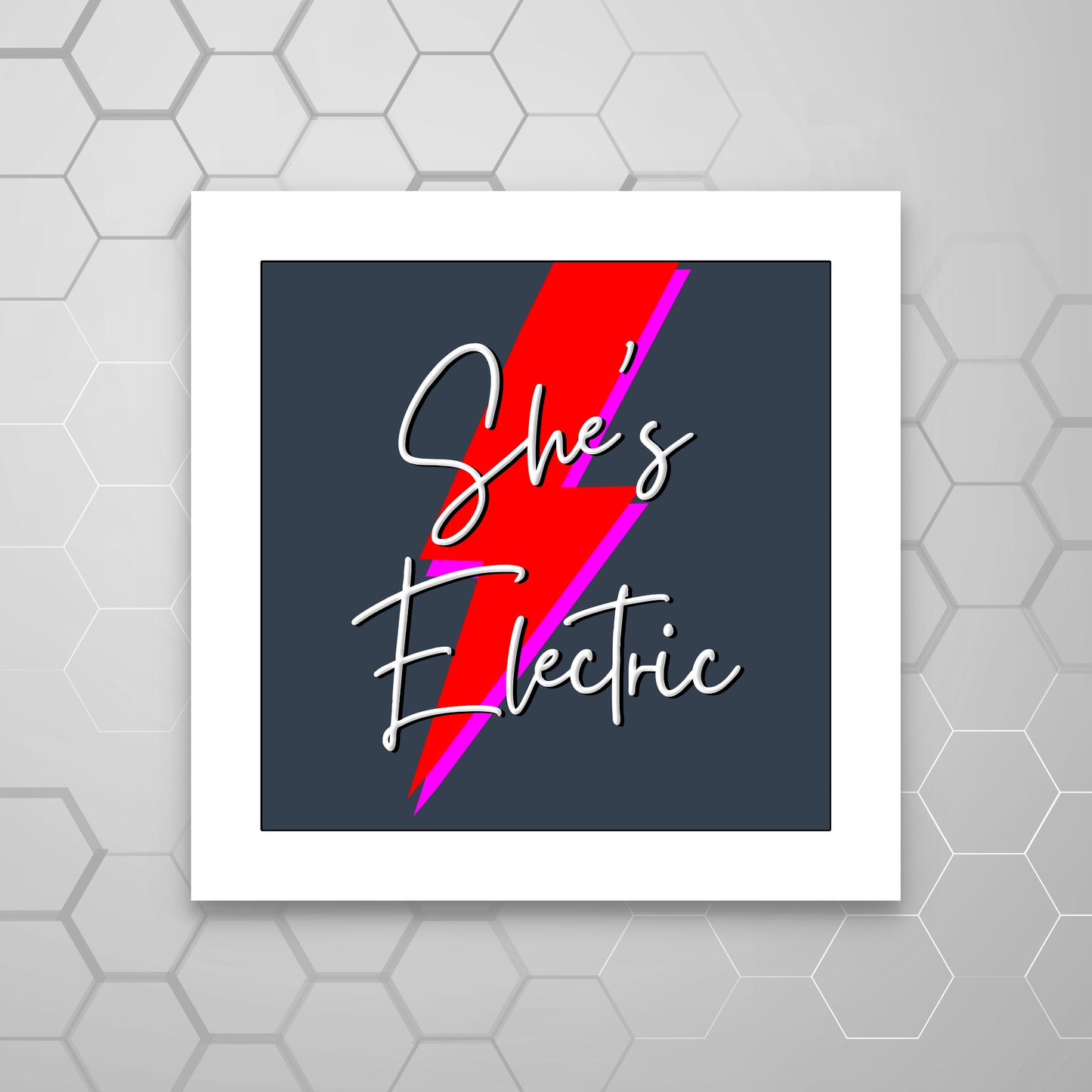 A MOUNTED graphic print with the text 'She's Electric' in stylized font, accompanied by a red and pink lightning bolt, mounted on a white board. OASIS LYRICS