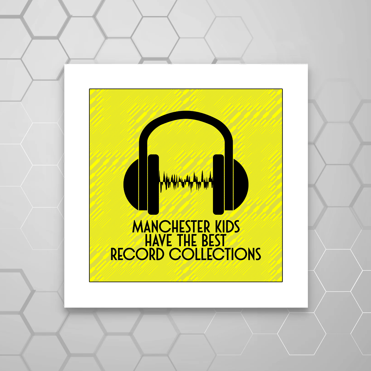 A square MOUNTED print with a yellow background featuring black text that reads 'MANCHESTER KIDS HAVE THE BEST RECORD COLLECTIONS' and a pair of headphones depicted above the text.