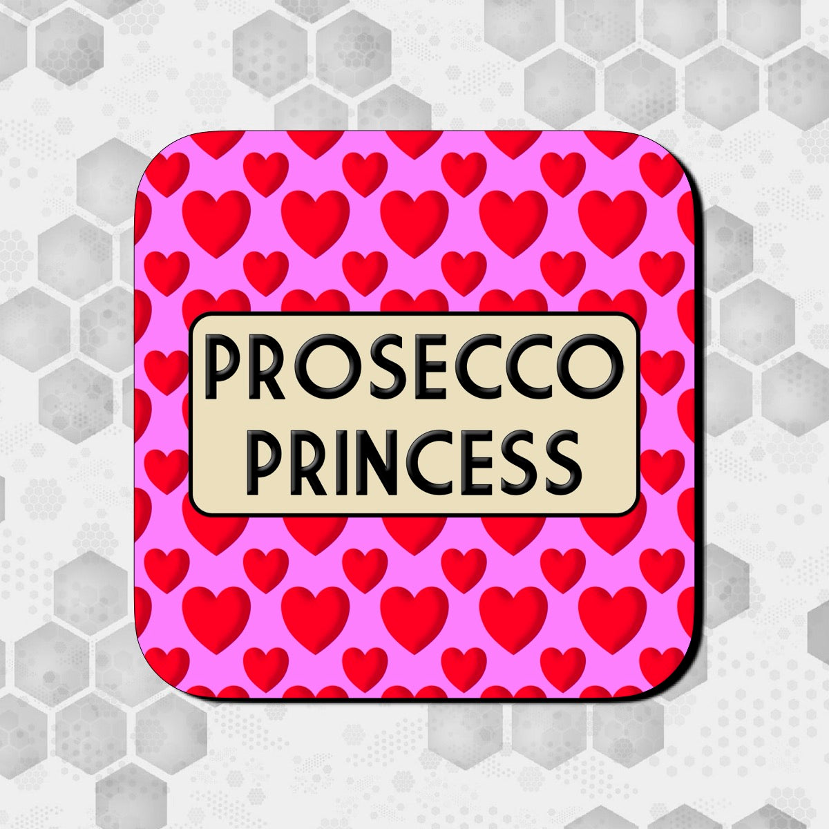 A square coaster with a pink background and red hearts pattern, with the text 'PROSECCO PRINCESS' in the center.