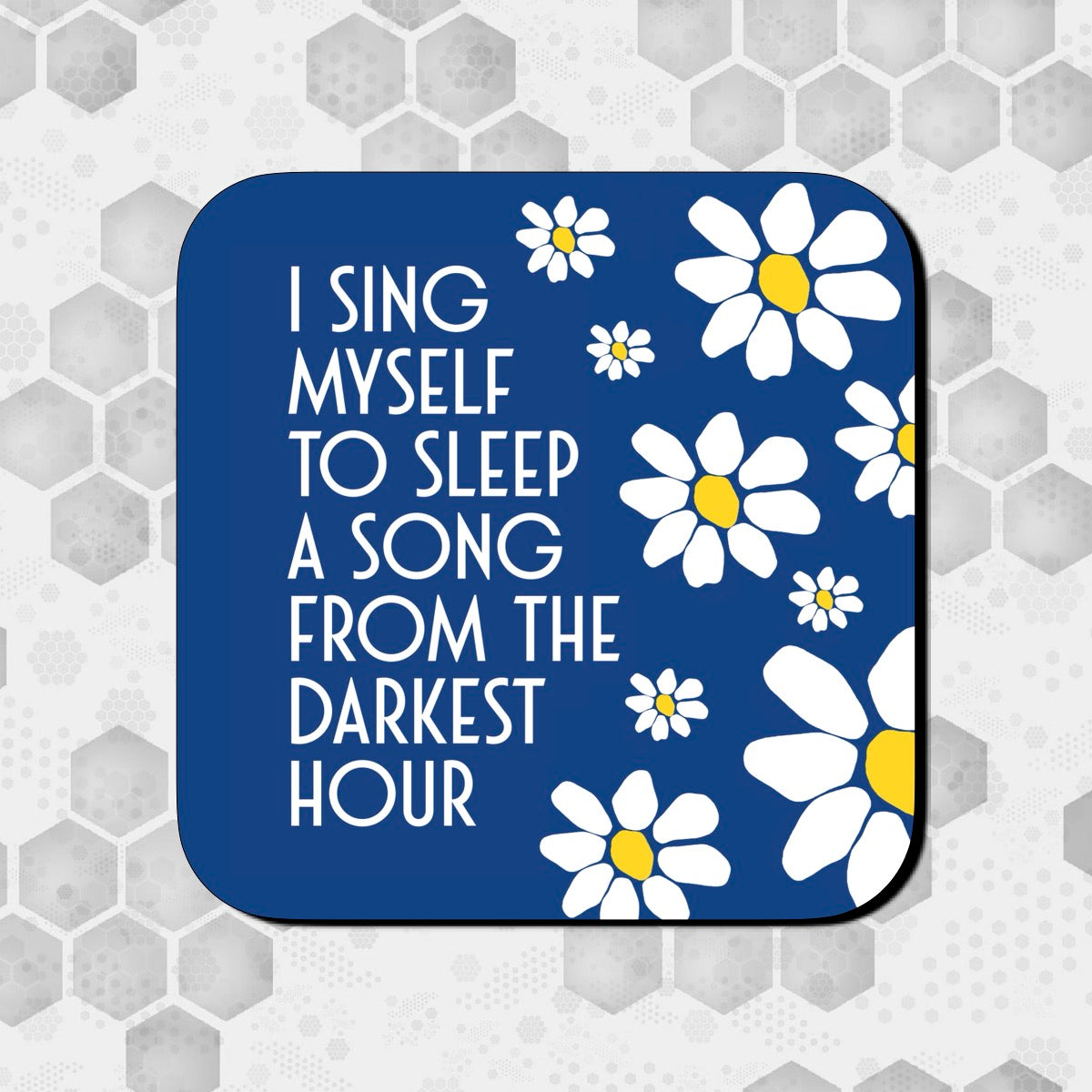 A square coaster with a blue background featuring white flowers and the text 'I SING MYSELF TO SLEEP A SONG FROM THE DARKEST HOUR'. JAMES LYRICS