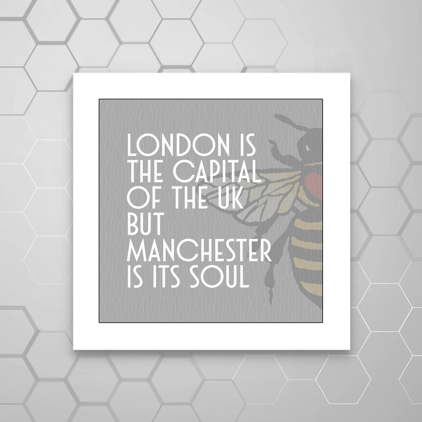 A MOUNTED print with a GREY BACKGROUND and A MANCHESTER BEE containing the text 'LONDON IS THE CAPITAL OF THE UK BUT MANCHESTER IS ITS SOUL'.