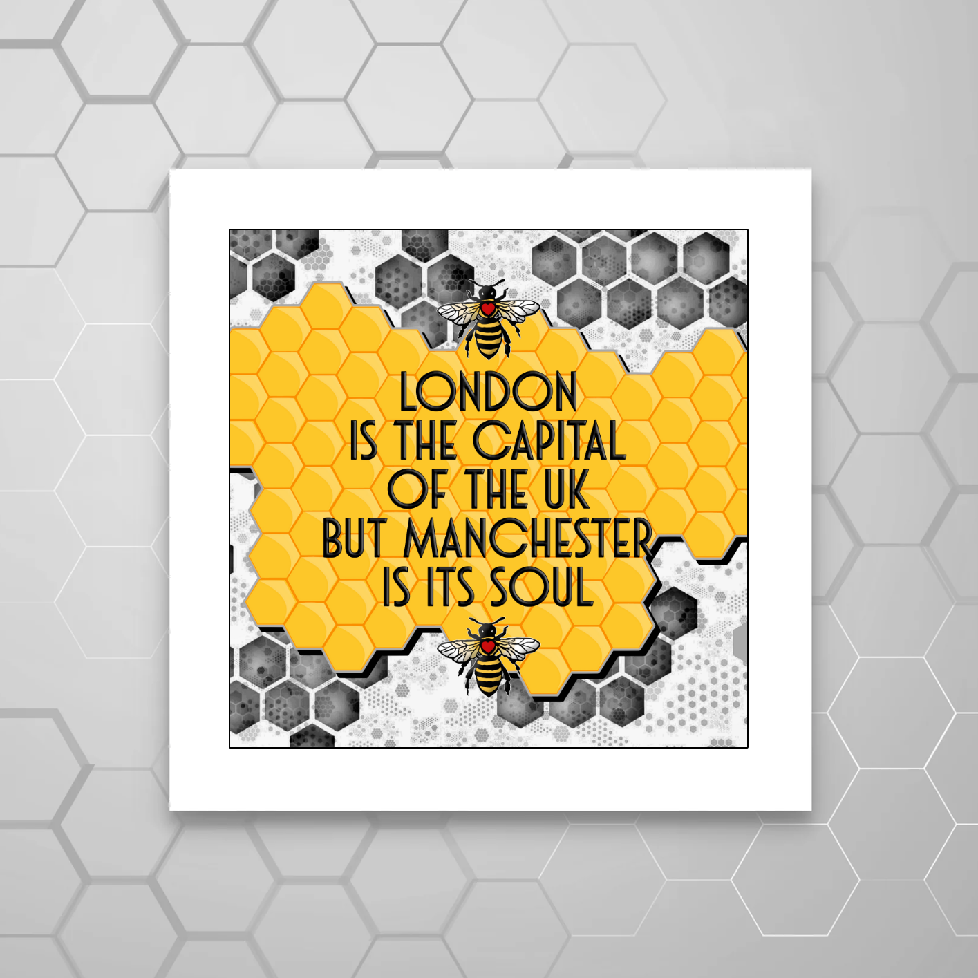 A MOUNTED print with a hexagonal pattern and yellow bees, containing the text 'LONDON IS THE CAPITAL OF THE UK BUT MANCHESTER IS ITS SOUL'.