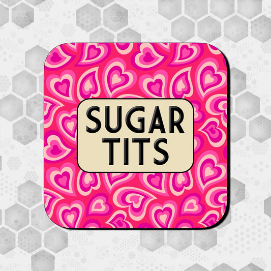 Coaster with a bright pink heart-patterned background, featuring a rounded beige box in the center with bold black text reading ‘Sugar Tits