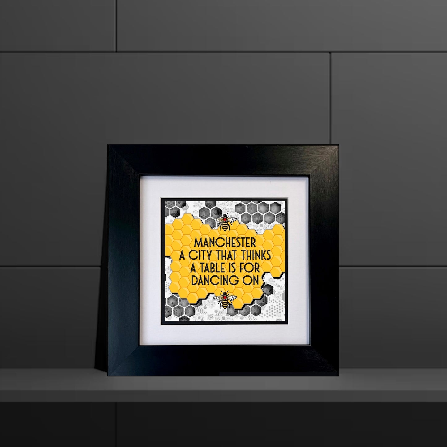 MANCHESTER A CITY THAT THINKS A TABLE IS FOR DANCING ON FRAMED PRINT YELLOW HONEYCOMB BACKGROUND.