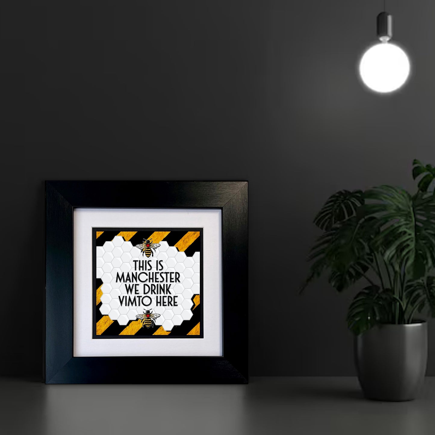 Framed print with 'This is Manchester, we drink Vimto here' text on a STRIPE YELLOW AND BLACK BACKGROUND TWO MANCHESTER BEES