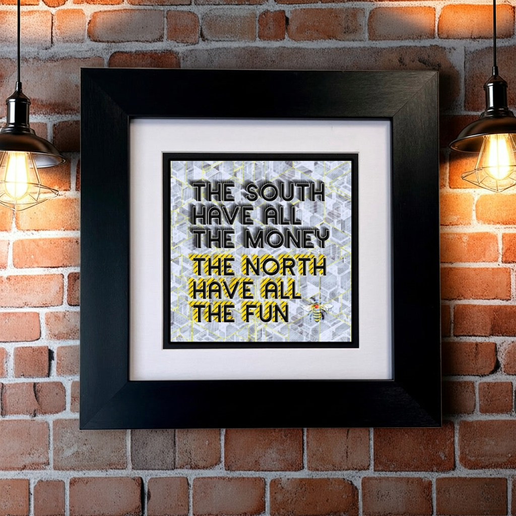 A framed print with the text 'THE SOUTH HAVE ALL THE MONEY THE NORTH HAVE ALL THE FUN' on GREY background, displayed against a white brick wall. SU MACE GIFTS