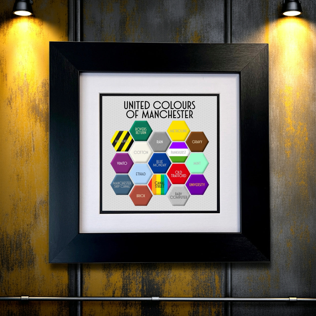 A colourful FRAMED print titled 'UNITED COLOURS OF MANCHESTER', featuring a honeycomb pattern with different colours and text elements representing various aspects of Manchester. SU MACE GIFTS