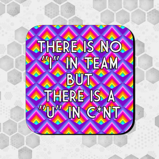 Coaster with a bold geometric rainbow pattern on a purple background, featuring large centered text that reads ‘There is no “I” in team but there is a “U” in c*nt