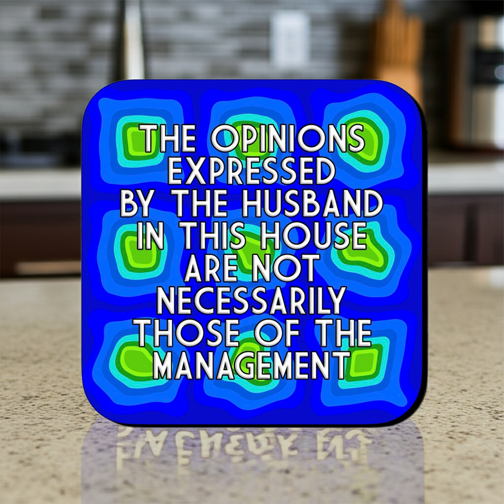 Coaster with a blue abstract layered pattern featuring green and teal geometric shapes, overlaid with bold centered text that reads ‘The opinions expressed by the husband in this house are not necessarily those of the management