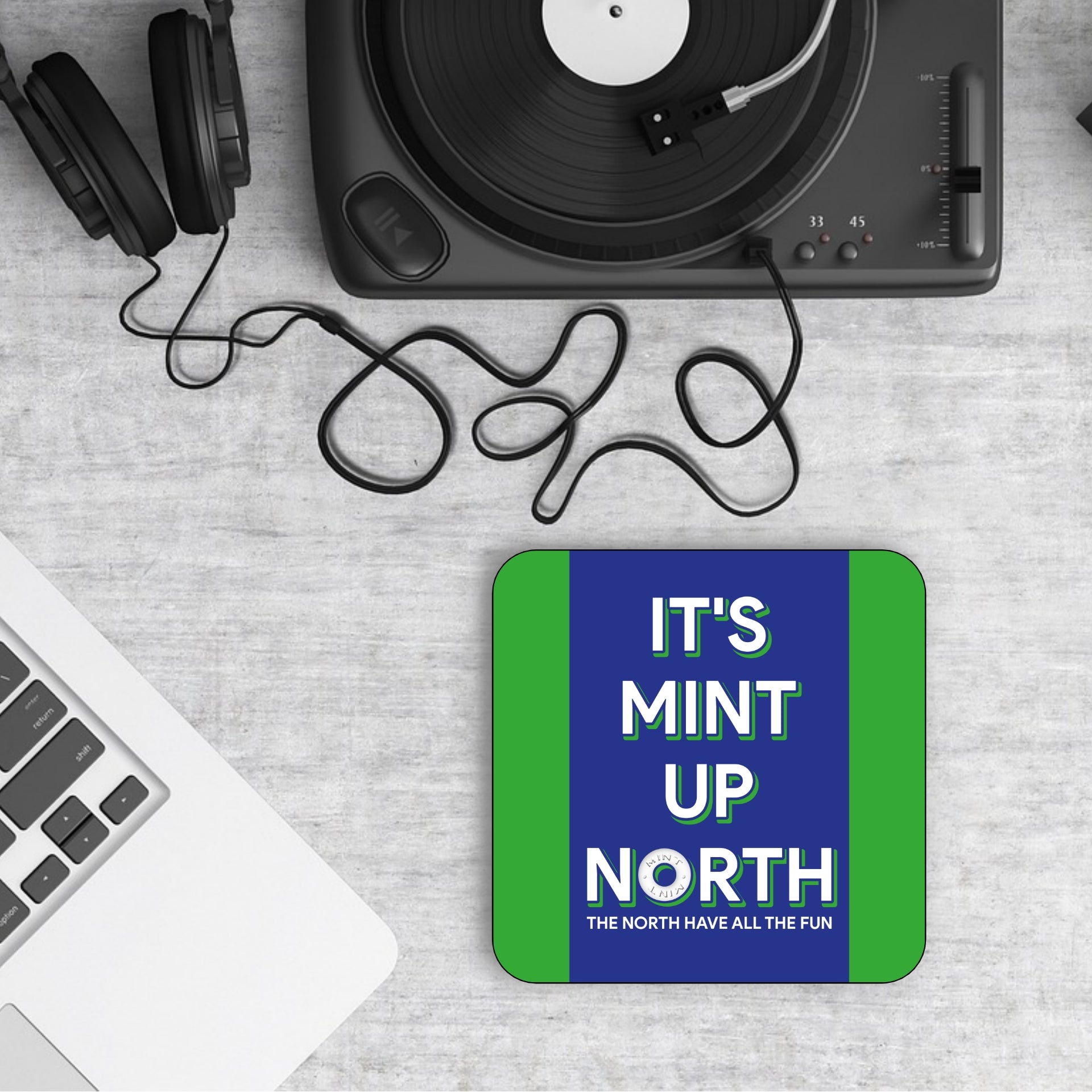 A square coaster with blue and green borders and white text that reads 'IT'S MINT UP NORTH' FEATURING A POLO MINT
