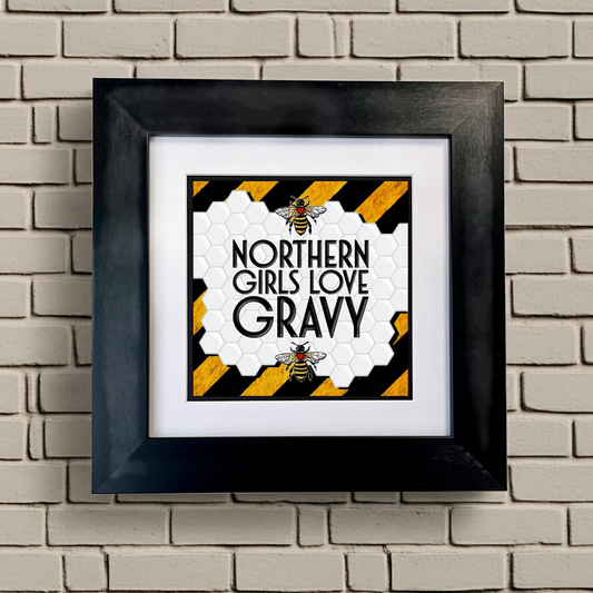 Framed artwork with 'Northern Girls Love Gravy' text on a brick wall background