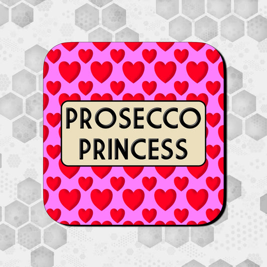 A square coaster with a pink background and red hearts pattern, with the text 'PROSECCO PRINCESS' in the center.
