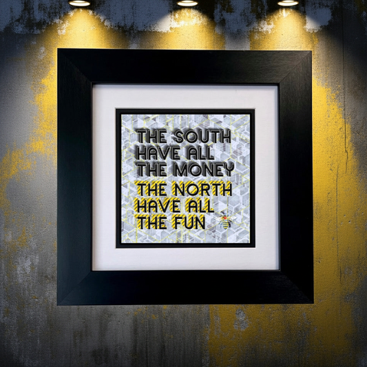 Framed print with text 'The South have all the money, The North have all the fun' on a textured wall background.